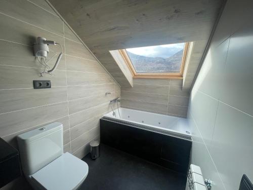a small bathroom with a toilet and a window at Hotel Vall d´Aneu in Esterri d'Àneu