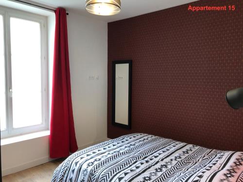 a bedroom with a bed with a mirror and a window at Les appartements du quai in Dieppe