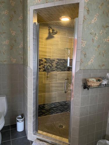 a shower with a glass door in a bathroom at Hanna House Bed & Breakfast in New Bern