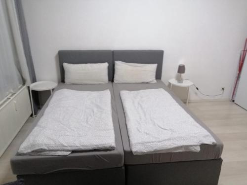 Wohnung in Köln 2B في كولونيا: غرفة نوم بسريرين مع شراشف بيضاء