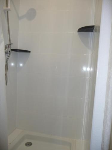 La salle de bains blanche est pourvue d'une douche et de toilettes. dans l'établissement Appart-Hotel T1 Lyon8 proche hopitaux, à Lyon