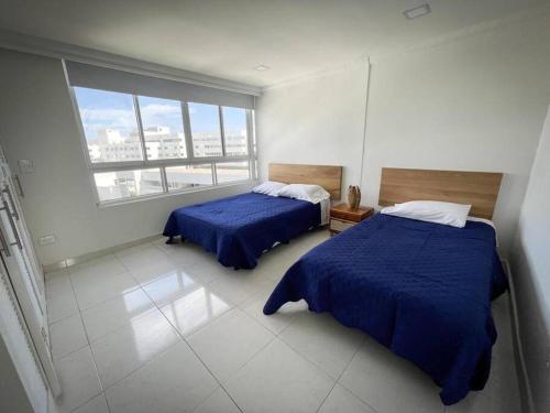 a bedroom with two beds and a large window at Bahia Maria in San Andrés