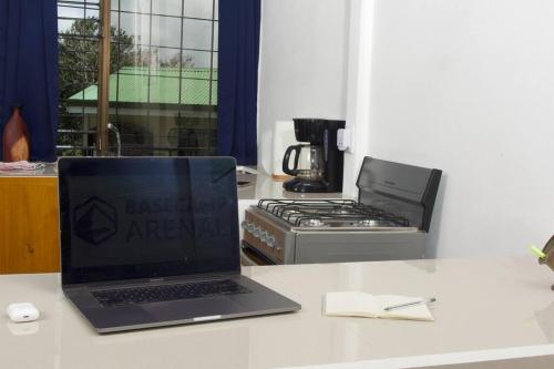 Basecamp Arenal في Tronadora: جهاز كمبيوتر محمول موجود على كونتر بجوار موقد