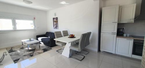 a living room with a table and a kitchen at Seastar Luxury apt with PRIVATE POOL and sea view in Novalja