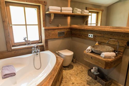 a bathroom with a bath tub and a toilet at Alpenchalet Reit im Winkl in Reit im Winkl