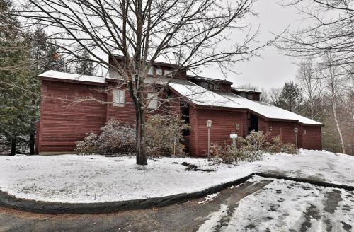 a red brick house with snow in front of it at Kettle Brook G in Ludlow