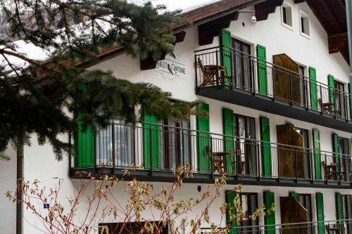 a building with green shutters and balconies on it at Chalet Antoine serviced Apartments by Mirabeau in Zermatt