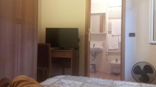 a bedroom with a television and a desk with a bed at Residenza San Martino in Bologna