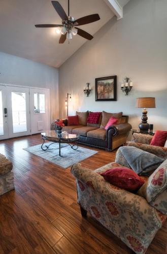 a living room with two couches and a ceiling fan at Home On the Green in Salado