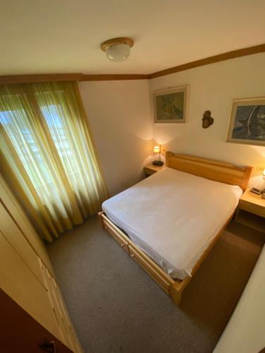 um pequeno quarto com uma cama e uma janela em Trilocale accogliente con camino a pochi minuti da Madonna di Campiglio em Spiazzo