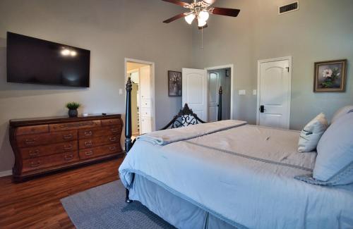 a bedroom with a large bed and a flat screen tv at Home On the Green in Salado