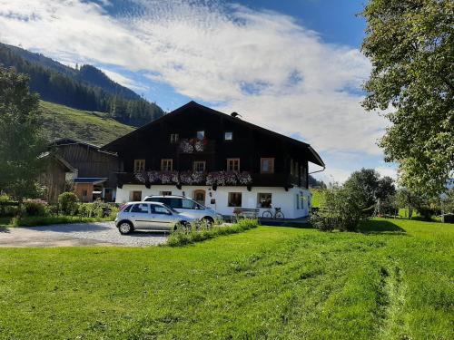 a house with a car parked in front of it at Appartement Huebgut in Bruck an der Großglocknerstraße