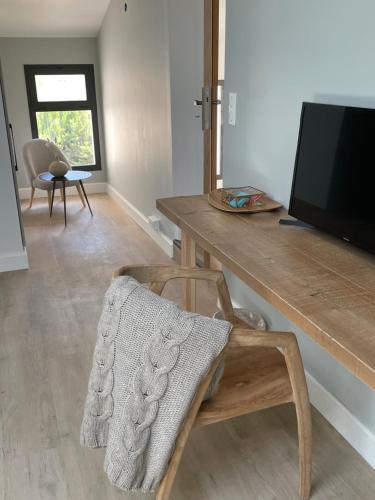 a living room with a wooden table and a chair at Villa La Carpenée in Roquefort-les-Pins