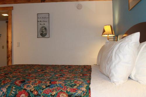 a bedroom with a bed and a picture on the wall at Wyatt Earp Hotel in Dodge City