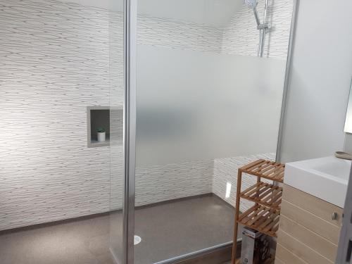 La salle de bains est pourvue d'une douche avec une porte en verre. dans l'établissement A la Campagne ,Halte ,Séjour et Détente, à Moncontour-de-Poitou