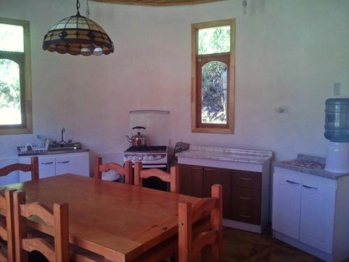 a kitchen with a wooden table and a dining room at Casa Alma in Vicuña