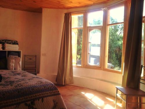 a bedroom with a bed and a large window at Casa Alma in Vicuña