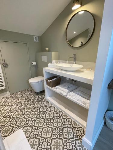 une salle de bain avec un lavabo, des toilettes et un miroir dans l'établissement Villa La Carpenée, à Roquefort-les-Pins