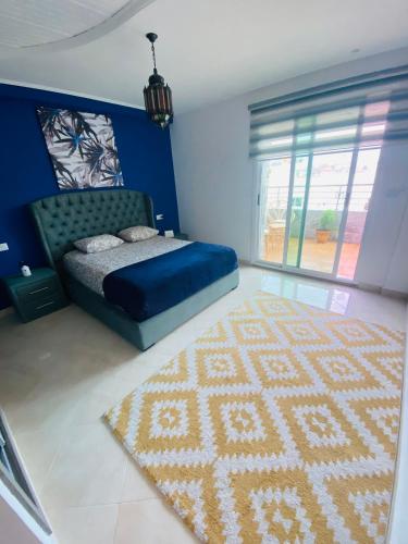 a bedroom with a bed and a rug and a window at welcom to castilla in Tangier