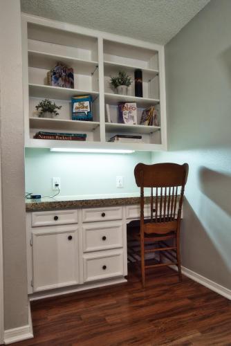 a desk in a room with a wooden chair at Home On the Green in Salado