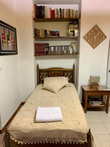 a bedroom with a bed and a book shelf with books at Casa Grande in Medellín