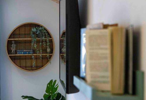 a shelf with a mirror and books on a wall at Chalet Antoine serviced Apartments by Mirabeau in Zermatt