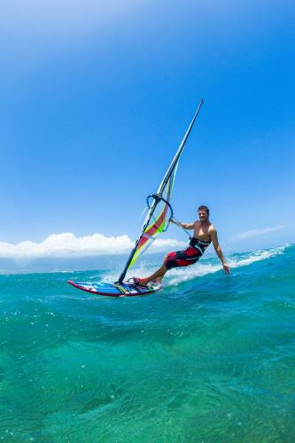 a man on a surfboard with a sail on the ocean at Solana Beach Mauritius - Adults Only in Belle Mare