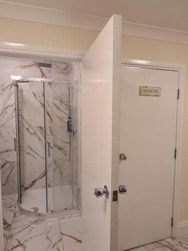 a bathroom with a shower with a glass door at Umbrella Properties London Excel in London