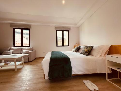 a bedroom with a large white bed and a couch at Living Funchal X in Funchal