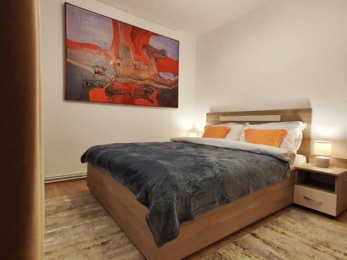 a bedroom with a bed and a painting on the wall at ARTment! A new and stylish apartment for you - Free parking in Braşov