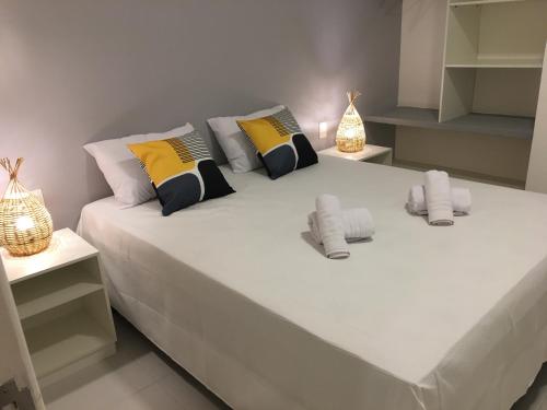 a large white bed with pillows on it in a room at Privê Portal do Sol in Porto De Galinhas