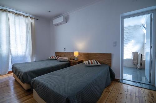 a bedroom with two beds and a large window at Hospedaria Santa Maria in Beja
