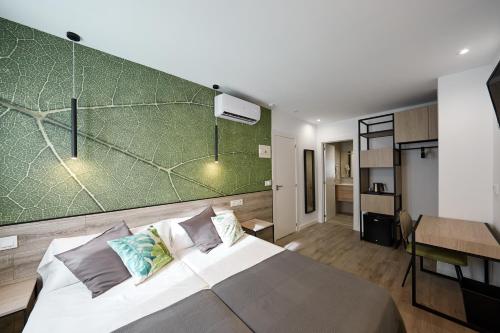 a bedroom with a large bed with a green wall at Enmathi Alicante Benalua in Alicante