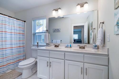 a bathroom with a sink and a toilet and a mirror at Luxurious Alberta Beach House w/ Historical Detail in Hampton