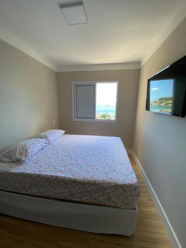 um quarto com uma cama e uma janela em Apto 15º andar - Varanda vista mar - Enseada no Guarujá