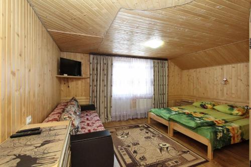 a room with two beds and a tv in it at Садиба "У Валентини" in Yablunytsya