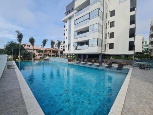 a large swimming pool in front of a building at Apartamento 2 quartos home club na praia de palmas in Governador Celso Ramos
