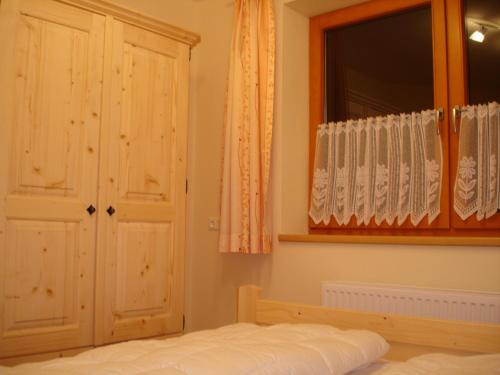 Schlafzimmer mit einem Bett und einem Fenster in der Unterkunft Haus Gföller in Niederau
