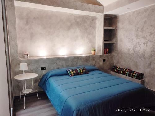 - une chambre avec un lit bleu et une table dans l'établissement Namavistu holiday house, à Catane