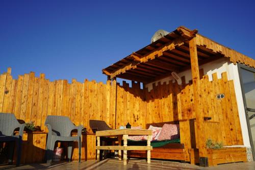 a wooden house with a table and a wooden fence at LA CASA DEL SOL IMSOUANE in Imsouane