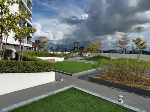 ogród z trawą i drzewami oraz budynek w obiekcie Meritus Apartment w mieście Perai
