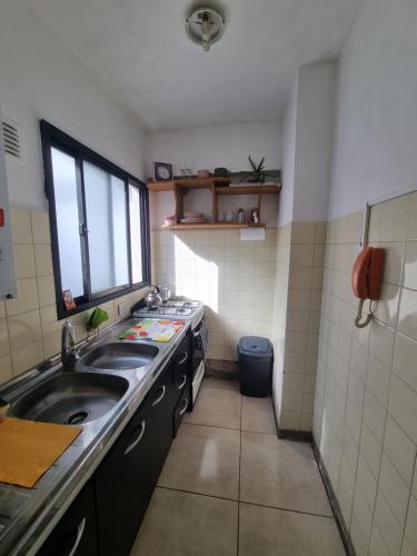 a small kitchen with a sink and a window at Monoambiente Libertad Barrio La Perla con cochera solo para autos in Mar del Plata