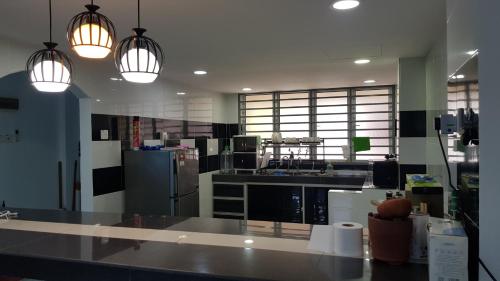 a kitchen with two pendant lights and a counter top at PD Batu 9 Cocobay apartment with family in Kampong Tanah Merah