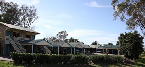 eine Reihe von Gebäuden in einem Park mit Bäumen in der Unterkunft Kilcoy Gardens Motel in Kilcoy