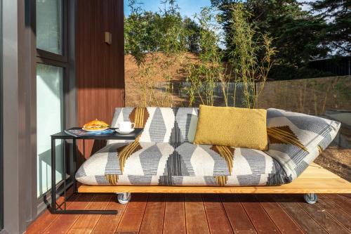 a couch sitting on a deck with a table at Omana in Rocky Bay