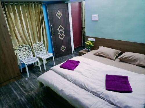 um quarto com uma cama grande e 2 cadeiras em SKYLARC VILLA - THE BEST VILLA IN OOTY em Ooty