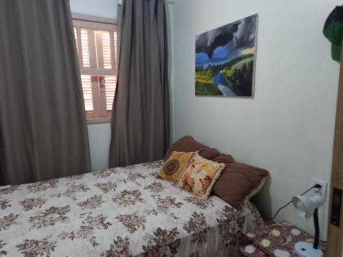 een slaapkamer met een bed met een kussen erop bij Casa perto do centro in Garopaba