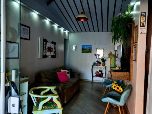 una sala de estar con un sofá y una silla en Casa perto do centro, en Garopaba