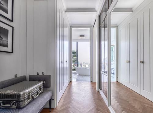 a hallway with a couch and a bathroom with a tub at The Langham, Jakarta in Jakarta