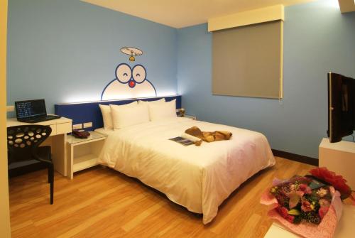 a bedroom with a bed with a teddy bear on it at Persimmon Hotel in Hsinchu City